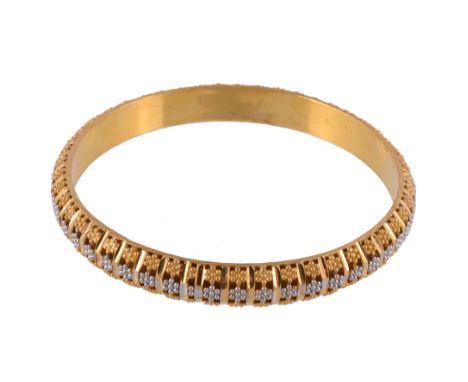  A gold coloured bangle,   the hollow bangle with beaded flower head decoration with facetted bars between, stamped Euro22c, 
