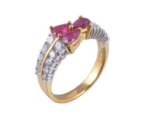  A ruby and diamond ring,   the three pear cut rubies claw set between brilliant cut and baguette cut diamond set shoulders, 