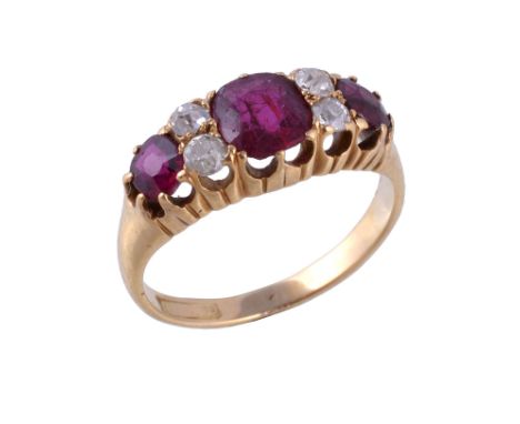  An early 20th century ruby and diamond ring,   the central cushion cut ruby claw set between old cut diamonds, approximately