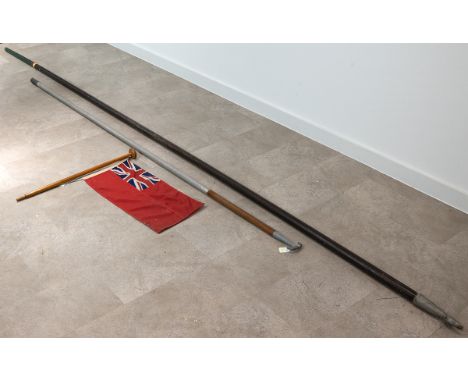 Vintage British Red Ensign flag on a wood flag pole, along with narrow boat quant pole and boat hook.