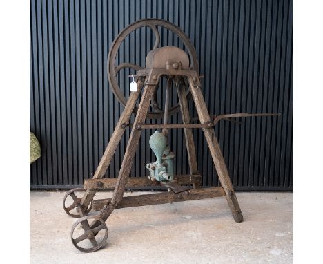 Vintage cast iron mobile water pump, standing on an oak frame, H 109cm, L 131cm.&nbsp;