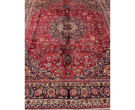 Large red ground Persian Mashad carpet, overall on a red ground with floral and foliate designs, central medallion with repea