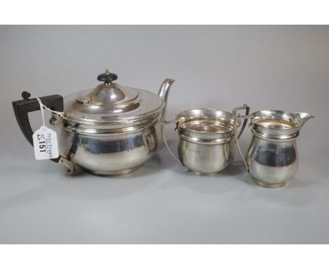 George V silver three piece tea service comprising; two handled sucrier, cream jug and teapot with ebonised finial and handle