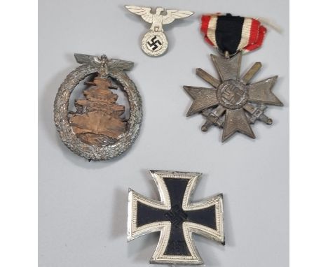 German 2nd World War Iron Cross First Class, a Kriegsmarine High Seas Breast badge, a Nazi Merit Cross and a Nazi winged Eagl
