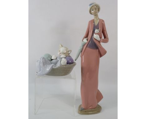Two Nao figurines, one of a lady holding a kitten and one of a kitten in a basket. The tallest measures 12.5"