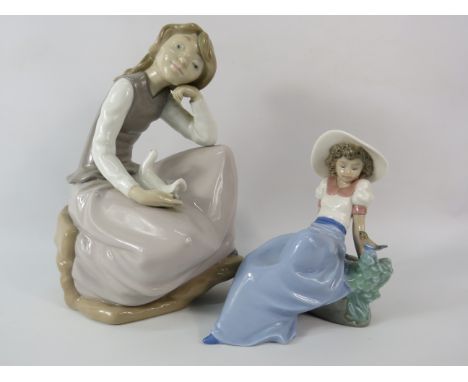 Large Nao figurine of a girl with a dove plus one smaller of a girl and a bird. The tallest measures 9.5"