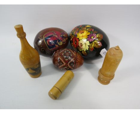 Three handpainted wooden eggs, a Mauchline ware thimble holder and two wooden needle holders.