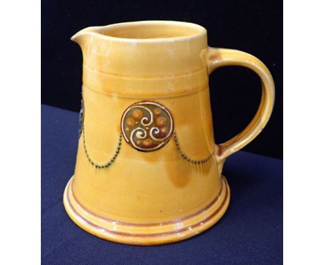 C.H. BRANNAM, BARNSTAPLE, FOR LIBERTY an arts and crafts yellow glazed pottery jug, with slip Celtic style roundels and dotte