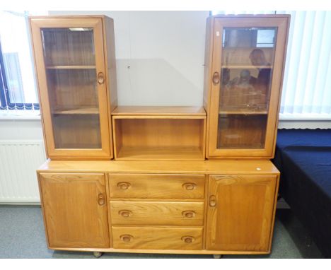 AN ERCOL ELM DRESSER the upper part with central niche flanked by two glazed cupboards, base fitted three drawers flanked by 