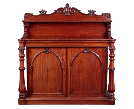 A VICTORIAN FIGURED MAHOGANY CHIFFONIER the back with floral and scroll carving and fitted single shelf, the base with turned