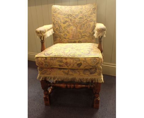 AN OAK-FRAMED UPHOLSTERED ARMCHAIR by Parker Knoll, in the 17th century style, in yellow tapestry fabric 