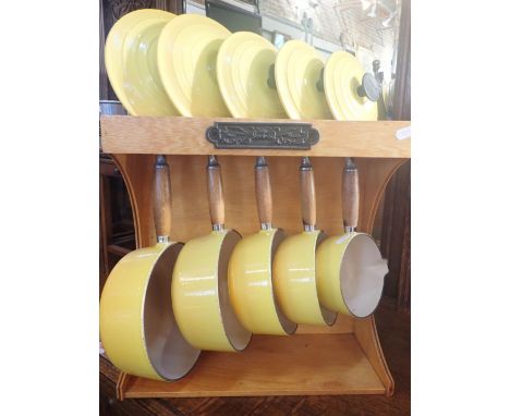 A SET OF LE CREUSET SAUCEPANS, WITH STAND in yellow enamel