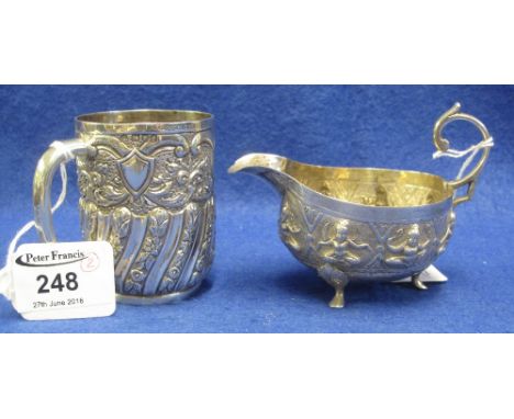 Indian silver small sauce boat with repousse figural decoration, together with a repousse decorated half lobed, wrythen strai