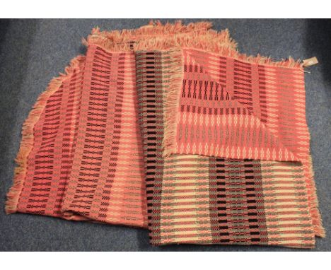 Two vintage pink, black and cream ground geometric double size Welsh carthen blankets both with a straight and a semi-circula
