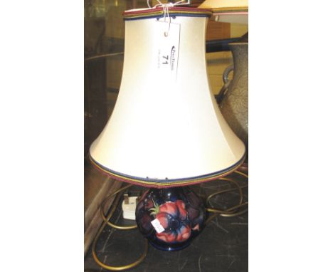 Small Moorcroft Art Pottery baluster shaped lamp base decorated with poppies on a dark blue ground and having fabric shade.(B