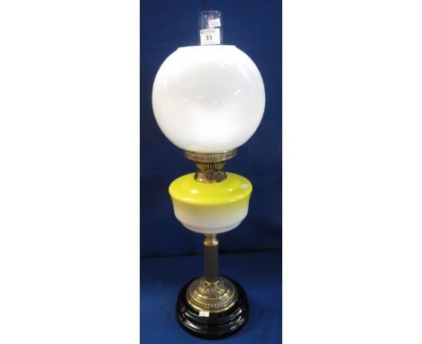 Early 20th Century brass double burner oil lamp with graduated yellow to white ceramic reservoir on a fluted, repousse brass 