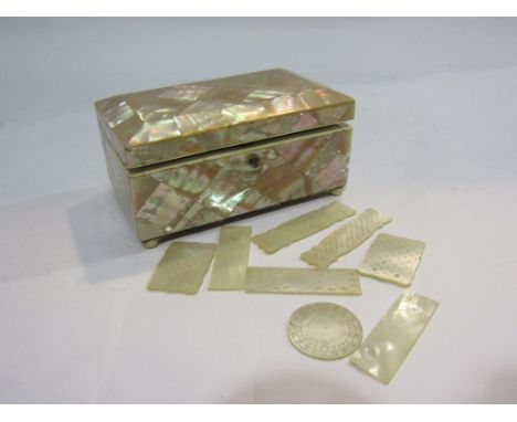 A 19th Century mother-of-pearl trinket box on bun feet with a selection of mother-of-pearl counters