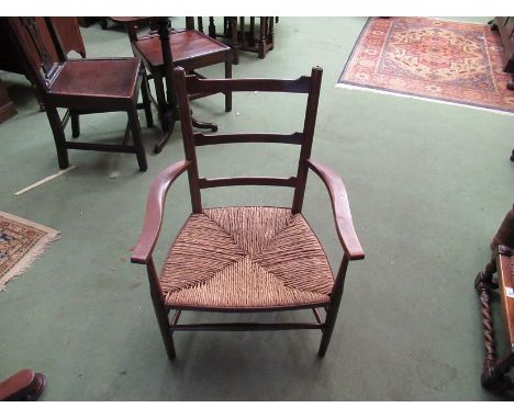 A pair of 19th Century North West Country oak and ash ladder-back elbow chairs with rush seats and spindle stretchers