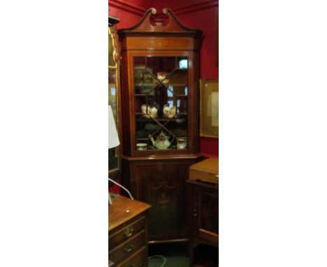 In the manner of "Maple &amp; Co" an Edwardian inlaid mahogany full height corner cabinet, the broken arch swan neck pediment