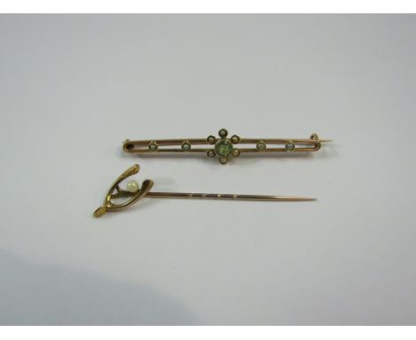 A gold peridot and seed pearl bar brooch stamped 9ct and a gold wishbone and pearl stick pin, unmarked