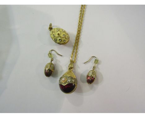 An enamel egg pendant hung on chain with a pair of matching earrings and egg pendant
