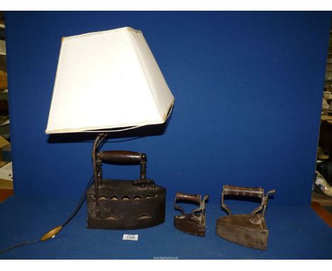 Three flat irons including one converted to a table lamp.