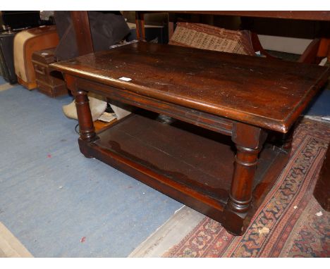 A dark stained peg-joyned coffee Table having turned legs united by a lower shelf and standing on turned legs, 36'' x 22'' x 