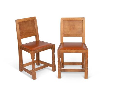 ROBERT THOMPSON OF KILBURN, A PAIR OF MOUSEMAN OAK DINING CHAIRS each with panel back, raised on faceted baluster legs contin