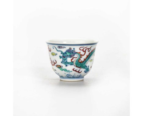 A CHINESE DOUCAI 'DRAGON' CUP circular, enamel painted with a dragon chasing a flaming pearl amidst clouds. 4.5cm high