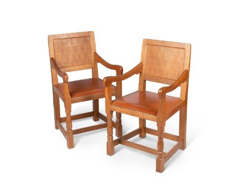 ROBERT THOMPSON OF KILBURN, A PAIR OF MOUSEMAN OAK ELBOW CHAIRS each with panel back, raised on faceted legs continuing to bl