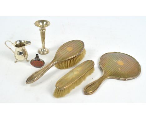 A George V hallmarked silver three piece dressing table set comprising a hand mirror, a hand brush and a clothes brush, Birmi