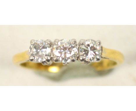 An 18ct yellow gold platinum mounted three stone diamond ring, each stone weighing approximately 0.20cts, size M. CONDITION R