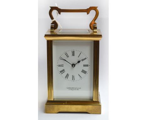 A 20th century brass cased carriage clock with swing loop handle above white enamel dial set with Roman numerals inscribed "G