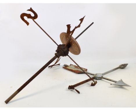 A wrought iron weather vane with upper section set with an arrow above letters set to the main frame.