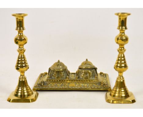 An ornately moulded rectangular double inkwell with ceramic liners, width 25.5cm and a pair of brass candlesticks, height 25c