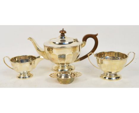 A George V hallmarked silver three piece tea service, each piece with flattened panels and raised on a stepped circular foot,