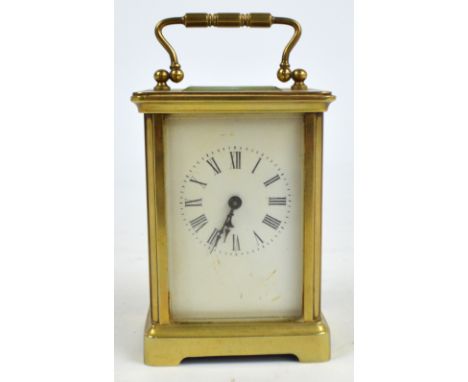 A small brass carriage clock, the white enamel dial with circular chapter ring set with Roman numerals, bevelled glass to top