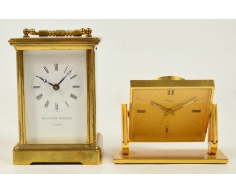 A brass carriage clock with white enamel dial, the circular chapter ring bearing Roman numerals and inscribed "Matthew Norman