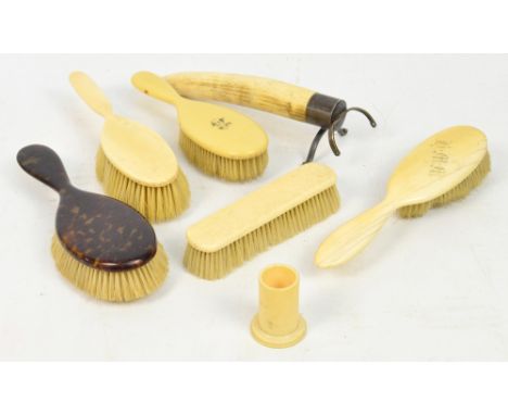 A small collection of ivory backed brushes, some with monograms, an ivory spill holder, a tortoiseshell backed brush and a Ge