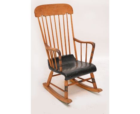 An early 20th century comb back elbow rocking chair with painted seat and ring turned front legs.