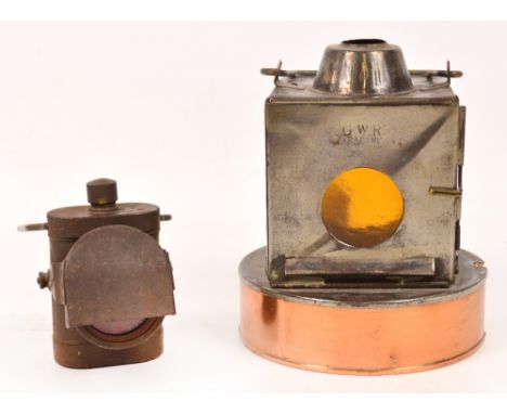 A vintage GWR metal lamp with a circular copper base, amber glass and a handle, impressed "GWR" and a signalling torch with r