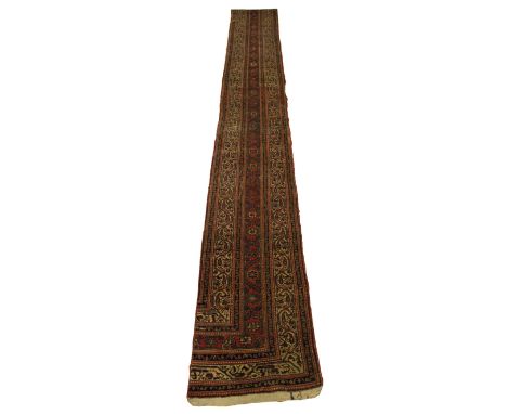 A hand knotted woollen runner, a fragment of a larger carpet, 415 x 54cm.