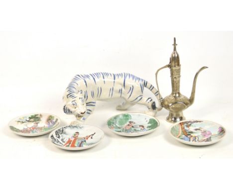 A modern ceramic Oriental model of a tiger with blue stripes, a set of four shallow dishes, decorated with figures in landsca