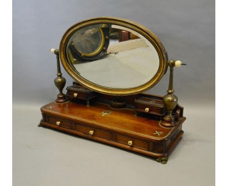 A 19th Century Mahogany Brass Inlaid Table Mirror, the oval mirror with patinated metal supports, above two jewel drawers and