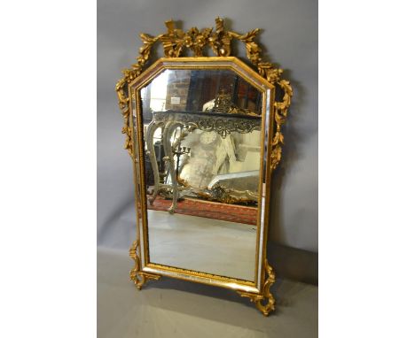 A French Gilt Framed Wall Mirror with a pierced carved cresting and scroll corner mounts, 93cm by 54cm 