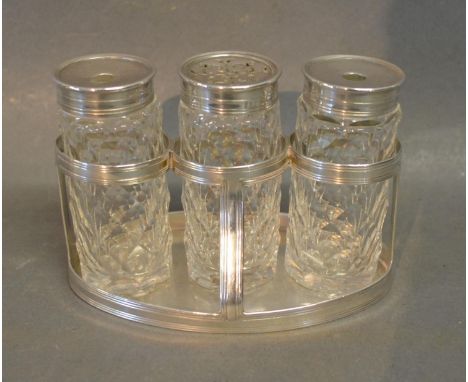 A George III Silver Desk Set, the stand of oval form with three cut glass bottles to include two inkwells and a sander, Londo