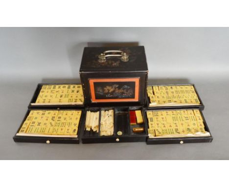 An Early 20th Century Chinese Mahjong Set, a lacquered case with gilded decoration, with five drawers containing Mahjong piec