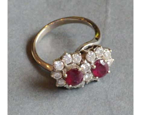 An 18ct. White Gold Ruby and Diamond Double Crossover Ring set with two rubies surrounded by diamonds within a pierced settin