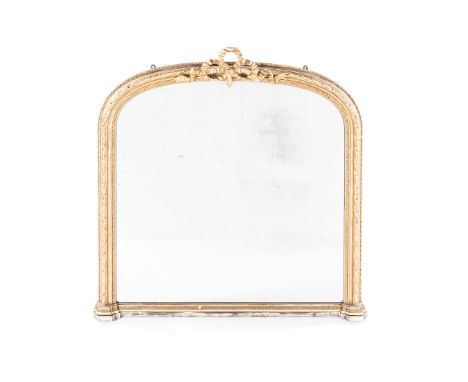 A GILTWOOD OVER MANTEL MIRROR the arched plate within a conforming frame, surmounted and centred by a pierced and carved ribb