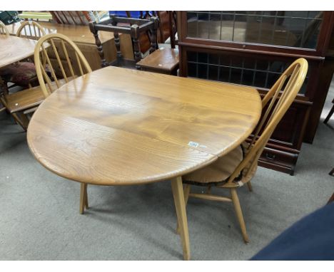 A blonde Ercol folding circular dining table together with 2 Ercole Quaker style dining chairs.